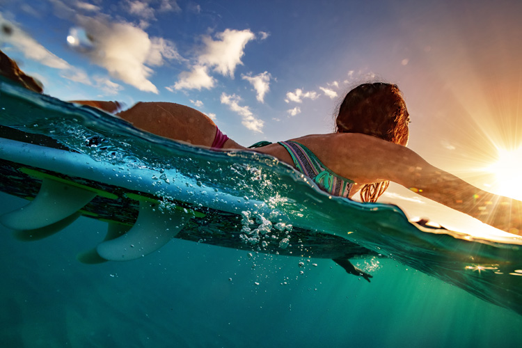 Remando: Os surfistas costumam colocar pressão na parte superior do corpo |  Foto: Shutterstock